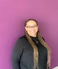 Ashley Bennett smiling with a pink background